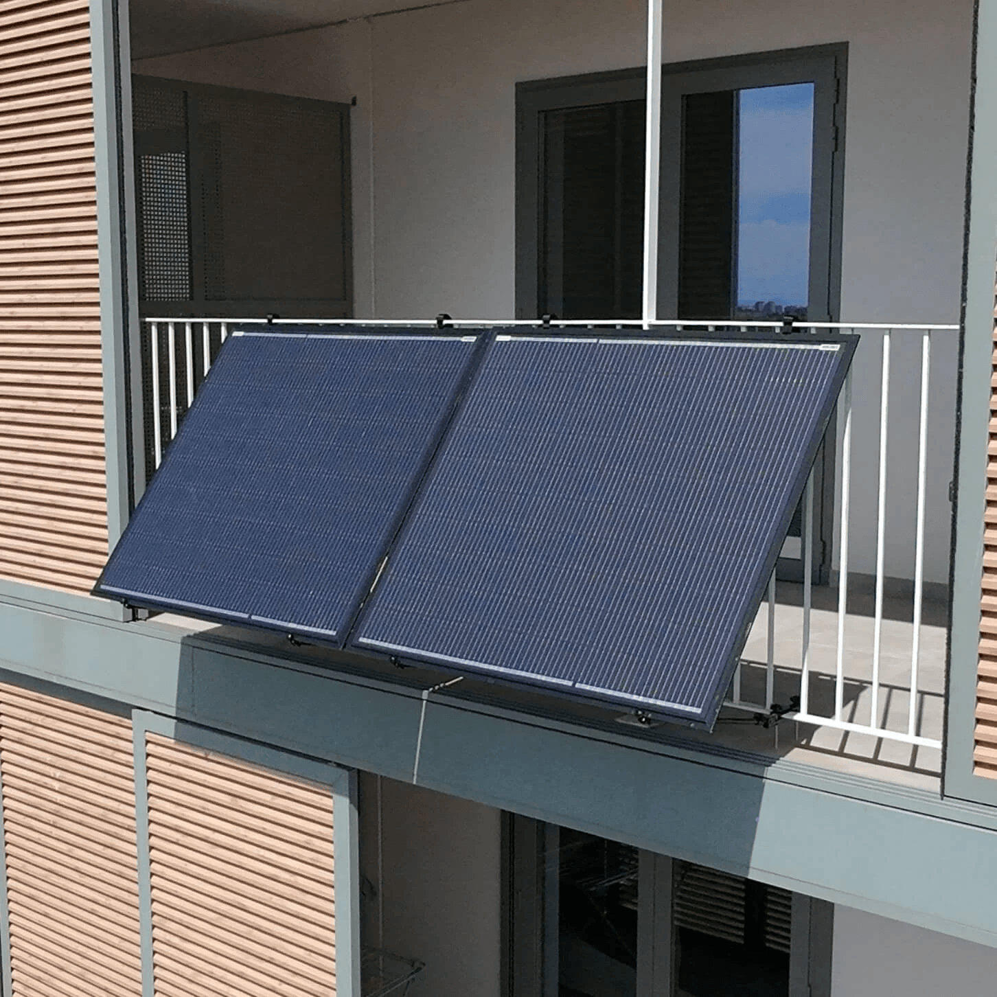 Apartment balcony solar panel array on white railing