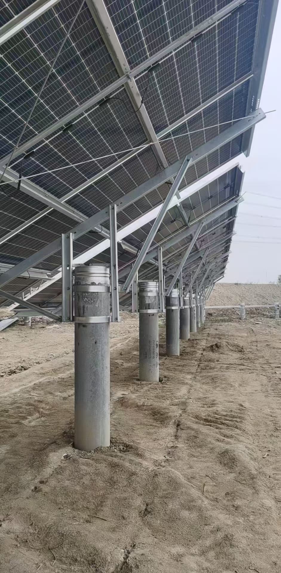 Steel ground mounting array with concrete pillars in field